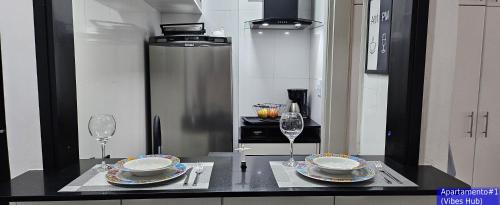 a kitchen with a table with two plates and wine glasses at Copacabana Vibes Studios in Rio de Janeiro
