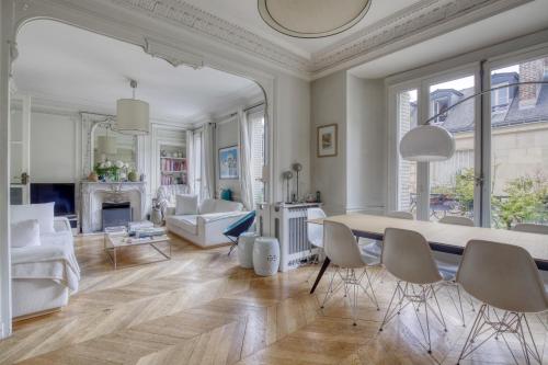 un salon blanc avec une table et des chaises dans l'établissement Appartement 3 chambre Marais Paris 4, à Paris