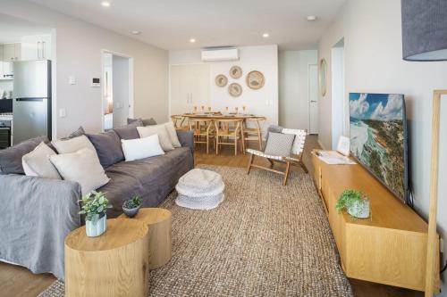 a living room with a couch and a table at Ocean Breeze Retreat: Kings Coastal Apartment in Caloundra