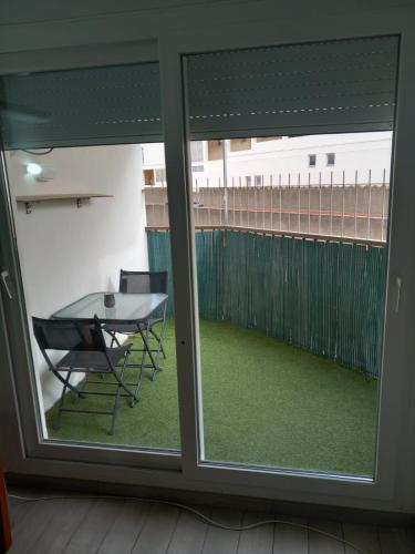 a view of a patio from a window with a table at Apartamento cerca del Mar in Empuriabrava