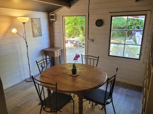 une salle à manger avec une table et des chaises en bois dans l'établissement Yourte et Chalet avec piscine, à Nivillac