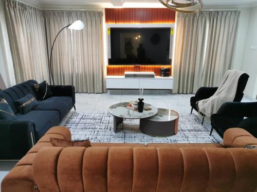 a living room with a couch and a tv at Summit Residence in Accra