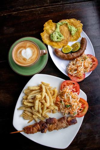 a table with two plates of food and a cup of coffee at Hotel El Tesoro Sonson in Sonsón