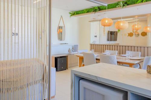 a dining room with tables and white chairs at Venice Home Club - Balneário Piçarras in Itajubá