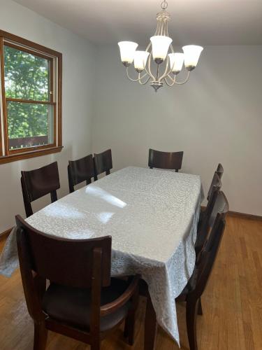 a dining room with a table with chairs and a chandelier at Perfectly located Waterhill home in Ann Arbor
