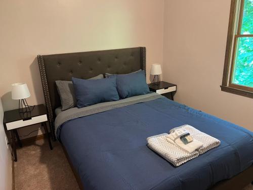 a bed with a blue comforter and a basket on it at Perfectly located Waterhill home in Ann Arbor