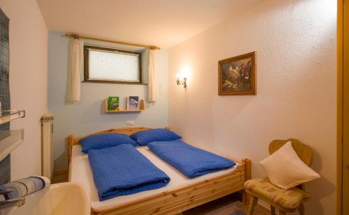 Un dormitorio con una cama con almohadas azules. en Haus Gabriele Appartement Frederic by NV-Appartements, en Kirchberg in Tirol