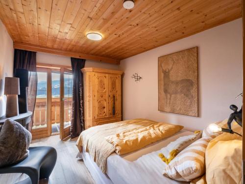 a bedroom with a bed and a chair at Teresa II Dachgeschosswohnung mit 2 Schlafzimmern - by NV-Appartements in Kirchberg in Tirol