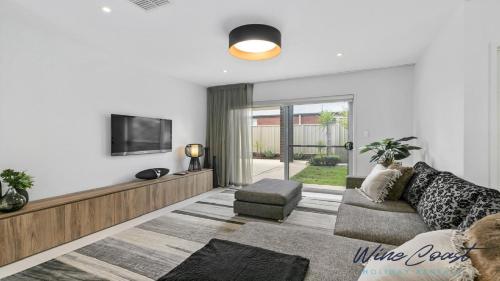 a living room with a couch and a tv at Oceans 19 by Wine Coast Holidays in Sellicks Beach