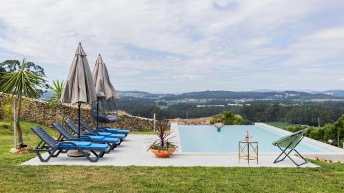 a group of chairs and umbrellas next to a swimming pool at Quintinha Sao Martinho Luxury 2 Suites Villa Padrao With Sauna in Vila do Conde