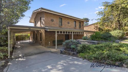 an old brick house with an open garage at Portavino by Wine Coast Holiday Rentals in Port Willunga