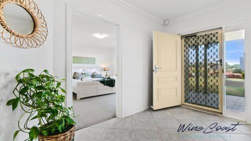a door leading to a bedroom with a bed at Sellicks Seacsape by Wine Coast Holidays in Sellicks Beach