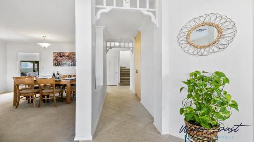 a dining room and kitchen with a table and a mirror at Sellicks Seacsape by Wine Coast Holidays in Sellicks Beach