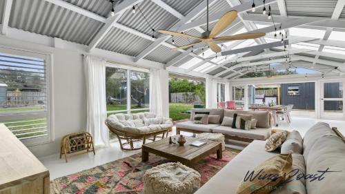 a living room with couches and a ceiling fan at Sea Gypsy by Wine Coast Holiday Rentals in Aldinga Beach