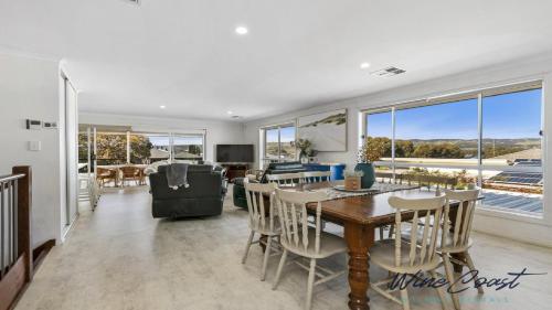 a dining room and living room with a table and chairs at R & R Aldinga Beach by Wine Coast Holidays in Aldinga Beach