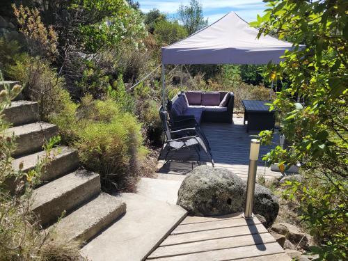 a patio with a chair and an umbrella on a deck at Lodge de Travo in Ventiseri