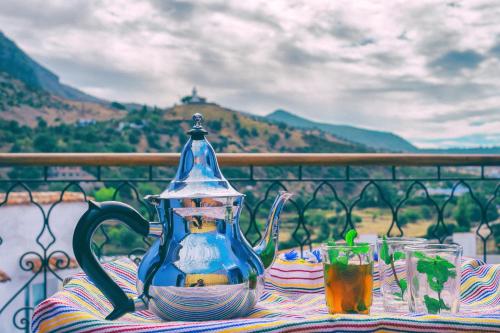 a table with a blue tea kettle and glasses on it at Casa Sabila in Chefchaouene