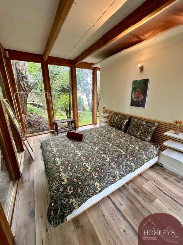 une chambre avec un lit dans une pièce avec des fenêtres dans l'établissement Maison d'architecte, romantique et insolite, à Alès