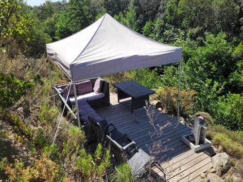 a tent with a table and chairs on a deck at Lodge de Travo in Ventiseri