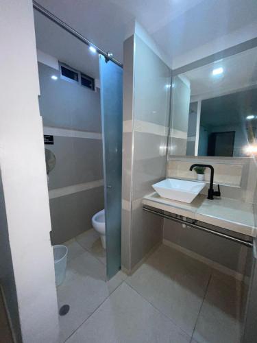 a bathroom with a sink and a toilet at Hotel Plaza Norte Cali in Cali