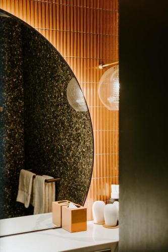 a bathroom with a round mirror and a sink at The Motley Hotel Richmond, Tapestry Collection by Hilton in Melbourne