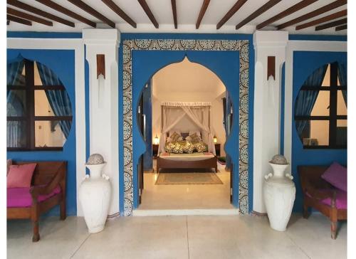 a bedroom with a bed with blue walls and vases at Blue Garden Boutique Hotel in Jepara