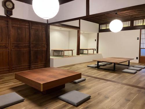 a room with two tables and benches in it at 志賀島のお宿 in Shikashima