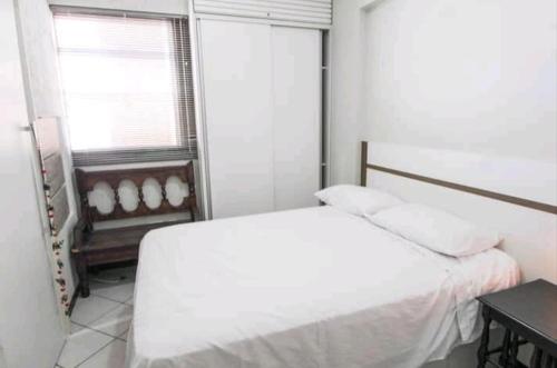 a white bedroom with a bed and a window at Flats Lago Norte MOTO CAPITAL 3 PESSOAS! in Brasilia