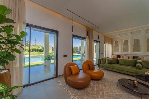 a living room with a couch and chairs and a pool at Villa Marrakech vue atlas in Marrakech