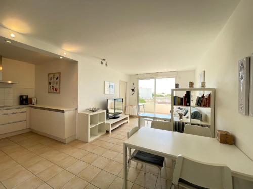 une cuisine et une salle à manger avec une table et des chaises dans l'établissement Bel Appartement T4 à Sète avec Terrasse, Climatisation et Parking Privé - FR-1-338-571, à Sète