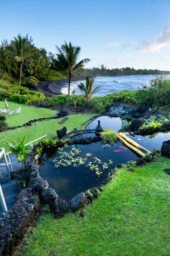 a pool of water with flowers in the grass at Hana Kai Maui - #204 Waiohinu, upper floor 1 BR in Hana