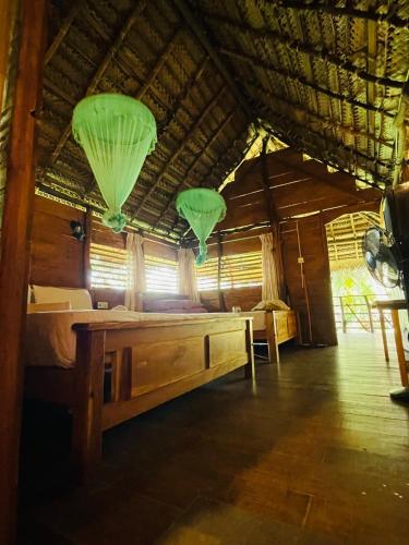 a room with a bed and two green paper lanterns at LakeSide Cabana Tissamaharama in Tissamaharama