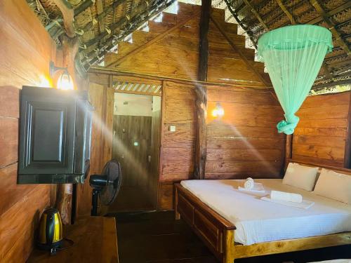 a small bedroom with a bed and a tv at LakeSide Cabana Tissamaharama in Tissamaharama