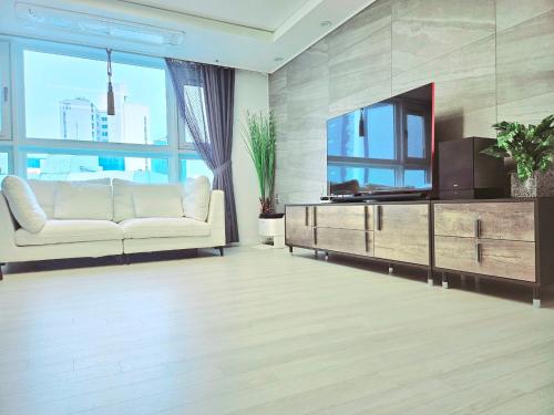 a living room with a couch and a television at Haeundae Chocho stay 2 in Busan