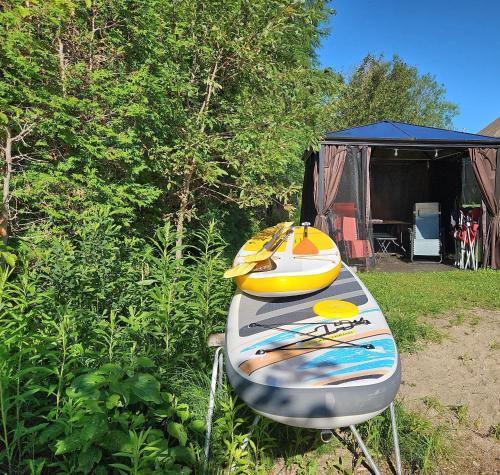 two surfboards sitting on a stand in front of a tent at Chalet Mathis in Saint-Raymond