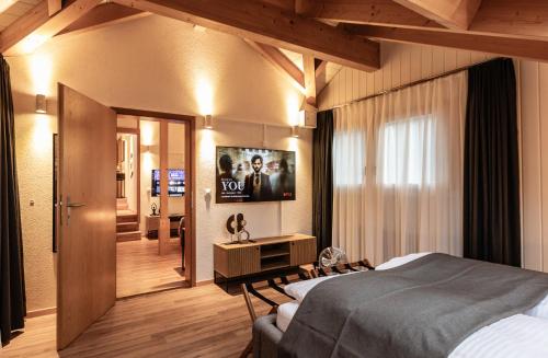 a bedroom with a bed and a tv on the wall at Spirit Apartments - The Penthouse - Lake View - Parking in Brienz