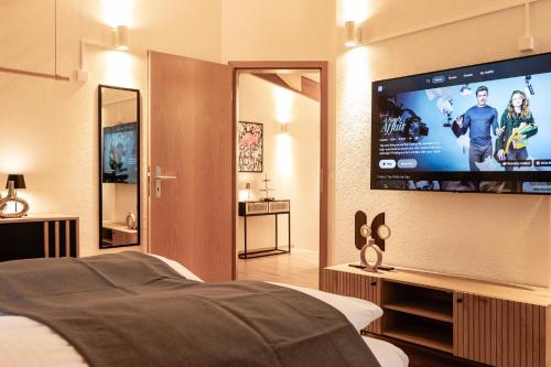a bedroom with a bed and a flat screen tv at Spirit Apartments - The Penthouse - Lake View - Parking in Brienz