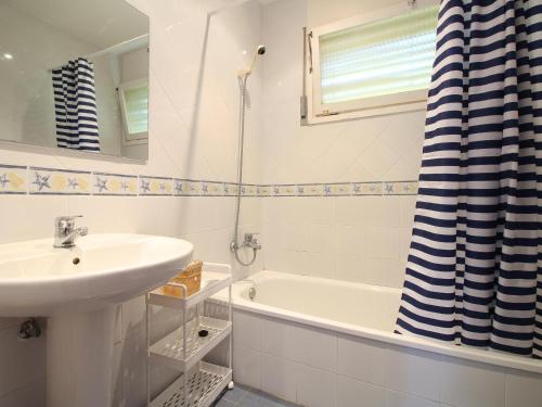 ein weißes Badezimmer mit Waschbecken und Badewanne in der Unterkunft Casa amplia con jardín a 100m de la playa de La Farella, cerca del puerto de Llançà - ES-228-168 in Llança