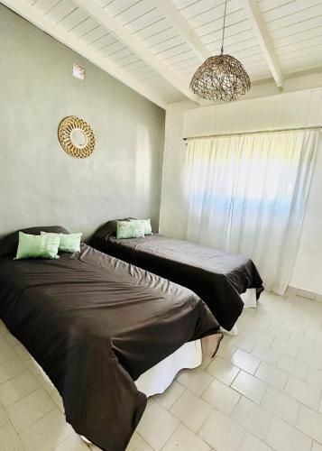 a bedroom with two beds and a chandelier at Casita Larraun- tu espacio cálido en la tranquilidad de Navarro in Navarro