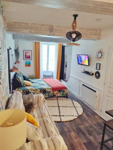 un salon avec un canapé et un lit dans l'établissement L'appartement de la rivière qui chante, à Nyons