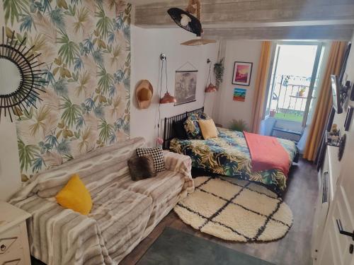 a small room with a couch and a bed at L'appartement de la rivière qui chante in Nyons