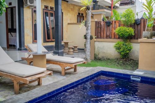 un cortile con piscina e due sedie e una casa di Twin OLA a Tabanan