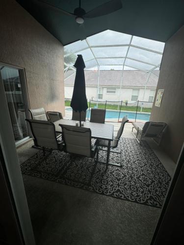 a dining room with a table and chairs and a pool at Minnie Heaven in Kissimmee