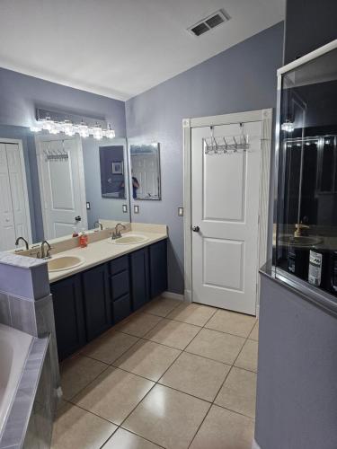 a bathroom with two sinks and a large mirror at Minnie Heaven in Kissimmee