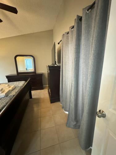 a bathroom with curtains and a vanity and a mirror at Minnie Heaven in Kissimmee