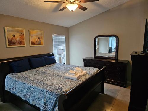 a bedroom with a bed with a dresser and a mirror at Minnie Heaven in Kissimmee