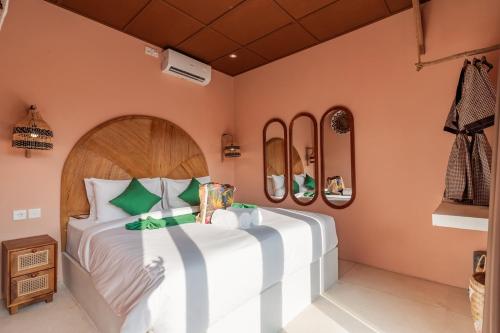a bedroom with a large bed and some mirrors at Woywoy Escape Tabo - Adults Only in Ubud