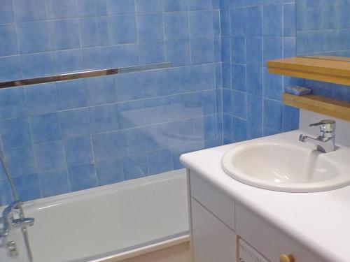 une salle de bain carrelée bleue avec un lavabo et une baignoire dans l'établissement Studio cabine, balcon, internet et animaux admis - FR-1-629-136, à Samoëns