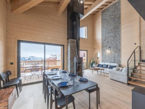 une salle à manger avec une table et des chaises et un salon dans l'établissement Duplex 125m² aux pieds des pistes avec parking et cheminée - FR-1-645-70, à Huez