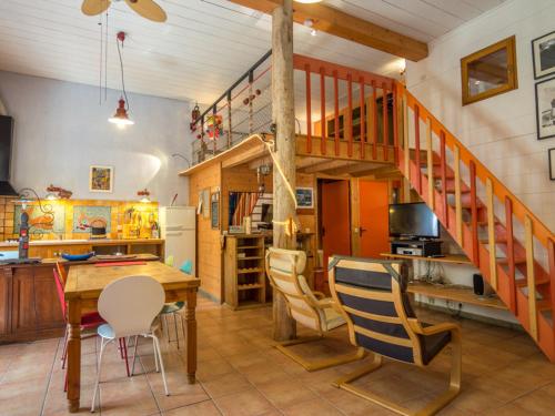 une cuisine et une salle à manger avec un escalier en bois dans l'établissement Loft atypique avec jardin à Mèze, proche commerces, plage et parc du château Girard - FR-1-604-49, à Mèze